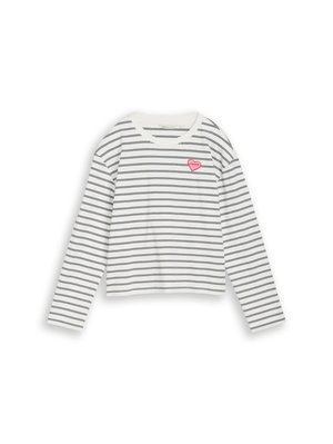 Balta krekla ar garām piedurknēm, ar plānām melnām horizontālām svītrām un mazu rozā sirds uzšuvi ar tekstu uz augšējās kreisās krūtis.