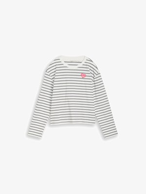 Balta krekla ar garām piedurknēm, ar plānām melnām horizontālām svītrām un mazu rozā sirds uzšuvi ar tekstu uz augšējās kreisās krūtis.