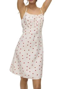 Vestido blanco con patrón de puntos rojos, tejido ligero, tirantes finos y cintura elástica para una silueta ajustada.