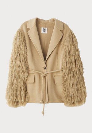 Beige Blazer mit Kunstpelzärmeln, ausgestattet mit einer einzelnen Knopfverschlüsse, zwei Fronttaschen und einem gebundenen Taillengürtel für eine verstellbare Passform.