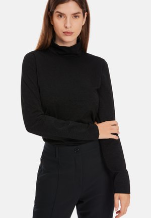Black turtleneck long-sleeve top with a fitted design, made from a smooth, stretchy fabric. Paired with tailored black pants featuring a button detail.