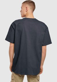Dark gray cotton t-shirt with short sleeves, a relaxed fit, and a crew neck. Visible stitching details and a smooth texture.