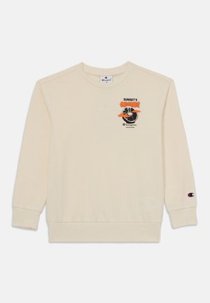 Sudadera color crema hecha de suave algodón con mangas largas. Presenta una impresión gráfica de naranjas y un logo en el pecho. Puños elásticos.