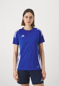Blauwe sportieve shirt gemaakt van lichtgewicht stof met witte zijstrepen en logo. Ronde halslijn, korte mouwen en getailleerde pasvorm.
