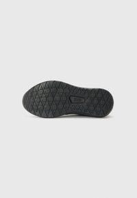 Black rubber shoe sole with a textured diamond pattern, featuring a central logo. Smooth edges and a rounded toe design.