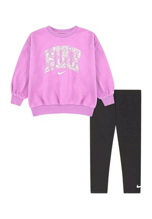 Felpa viola Nike con logo bianco decorato abbinata a leggings neri Nike semplici con un piccolo logo bianco vicino alla caviglia.