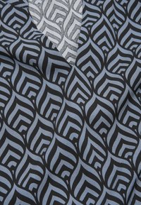 Black fabric with a geometric pattern in dark blue and light gray. Features a V-neck design with a textured gray panel at the top.