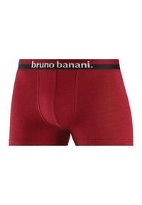 Röda bomullskalsonger med svart resårmidja som har varumärkesnamnet "bruno banani" i vita bokstäver. Slät textur och figurnära design.