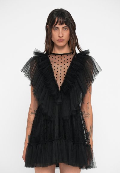 Schwarzes Tüllkleid mit einem transparenten gepunkteten Oberteil, Rüschensleeves und gestuftem Saum. Mit Lagen und Punkten strukturiert, um visuelles Interesse zu schaffen.