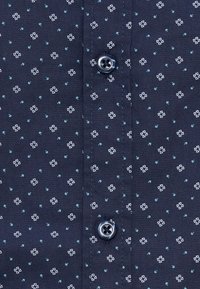 Tumesinine särk valge ja türkiissinise väikese geomeetrilise mustriga, ees plokil kaks nuppe nelja auguga.