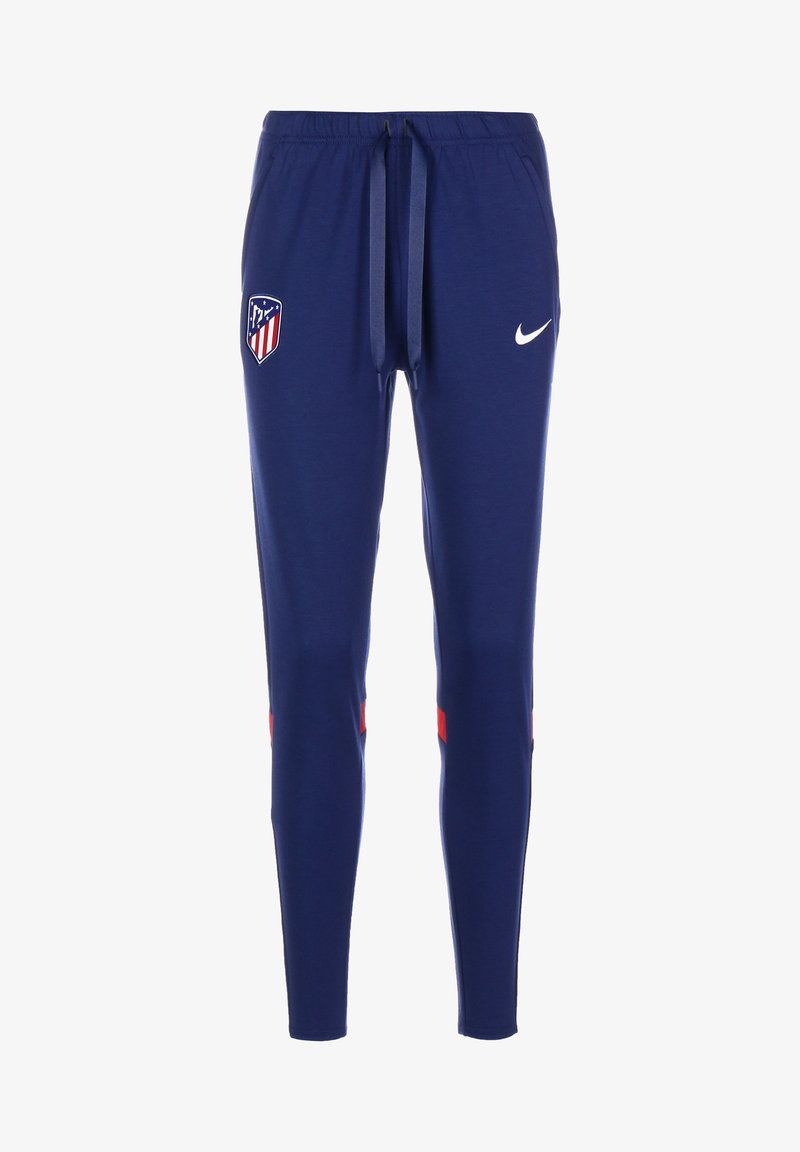 Pantalon de sport bleu marine avec taille ajustable, écusson du club Atlético Madrid sur la cuisse gauche, logo Nike blanc sur la cuisse droite et accents rouges près des genoux.