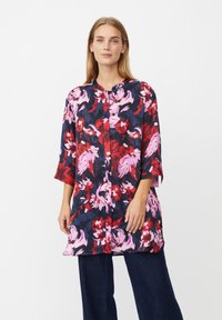 Blumige Tunika in Marineblau, Rot und Pink mit Dreiviertelärmeln und Rundhalsausschnitt; verfügt über eine Knopfleiste und eine lockere Passform.