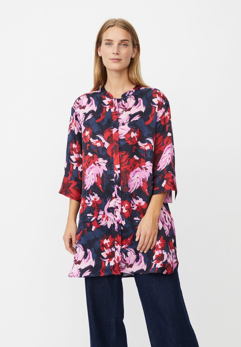 Blumige Tunika in Marineblau, Rot und Pink mit Dreiviertelärmeln und Rundhalsausschnitt; verfügt über eine Knopfleiste und eine lockere Passform.