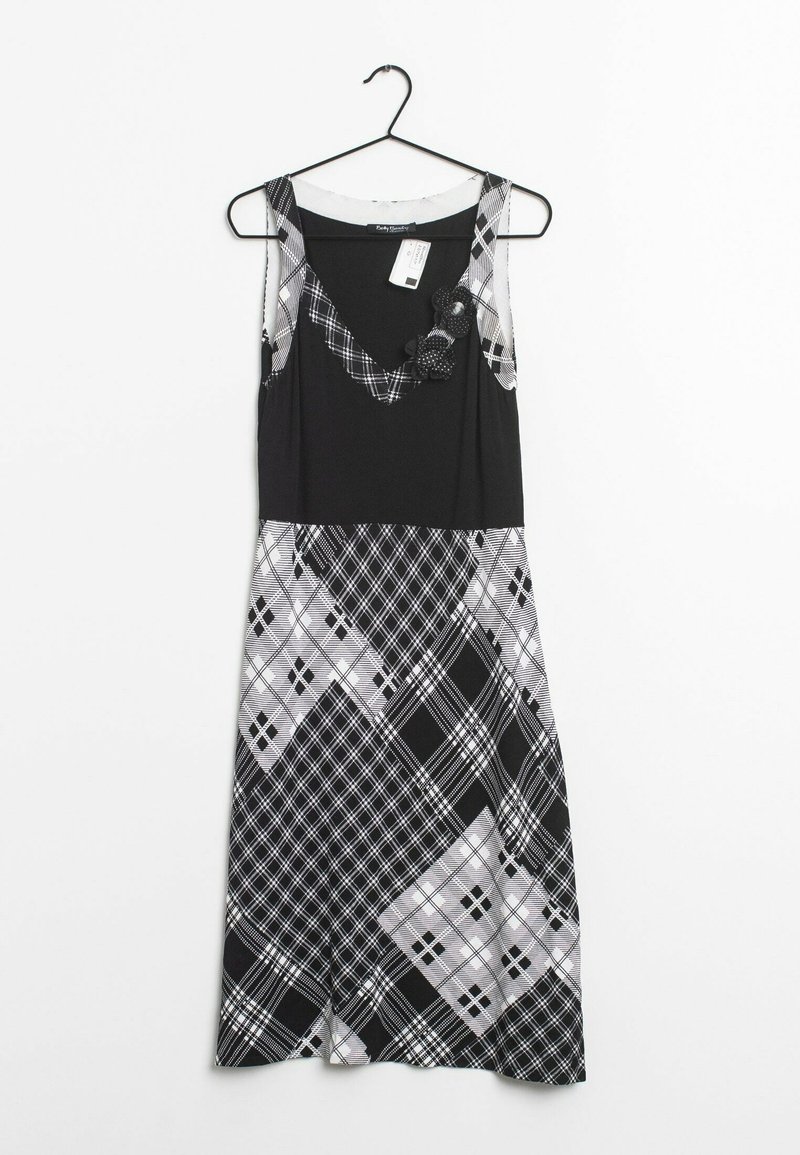 Sleeveless black dress featuring a plaid pattern in shades of gray. Textured accents on the neckline and a flowing silhouette.