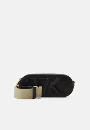 Schwarze ovale Crossbody-Tasche mit eingeprägtem "MK"-Logo, ausgestattet mit einem breiten, beigen verstellbaren Stoffriemen und goldfarbenen Beschlägen.