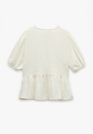 Haut ivoire pâle avec des manches courtes à volants, un ourlet peplum froncé, un motif floral texturé et un col rond.