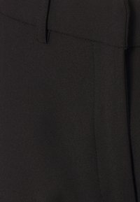 Zwarte stoffen broek met een gladde textuur, een op maat gemaakt ontwerp en strakke lijnen, met gestikte accenten en zonder zichtbare hardware.