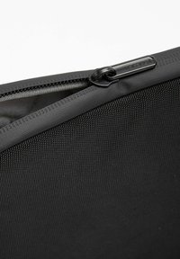 Schwarze gepolsterte Laptoptasche mit strukturiertem Äußeren, oberem Reißverschlussverschluss und glattem Innenfutter zum Schutz und sicheren Verstauen.