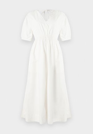 Λευκό βαμβακερό φόρεμα με V-λαιμόκοψη, κοντά φουσκωτά μανίκια, ζώνη με ελαστικό και αέρινη φούστα. Διαθέτει κλείσιμο με κορδόνι στο πίσω μέρος.