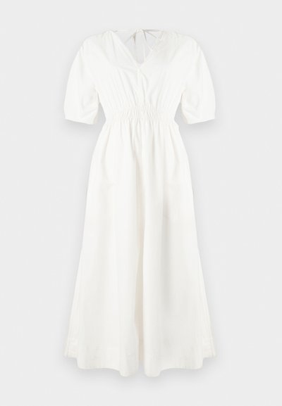 Λευκό βαμβακερό φόρεμα με V-λαιμόκοψη, κοντά φουσκωτά μανίκια, ζώνη με ελαστικό και αέρινη φούστα. Διαθέτει κλείσιμο με κορδόνι στο πίσω μέρος.
