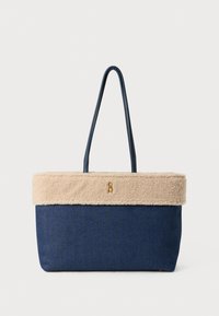 Geantă de umăr din denim cu o margine din blană faux bej, are două mânere și un accent cu logo auriu. Formă rectangulară, material texturat.