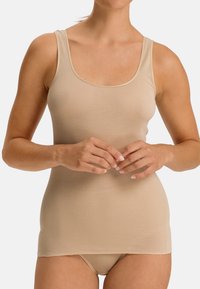 Canottiera beige realizzata in un materiale morbido e elasticizzato. Presenta un collo a barchetta e spalline larghe, che si estendono fino sotto i fianchi.