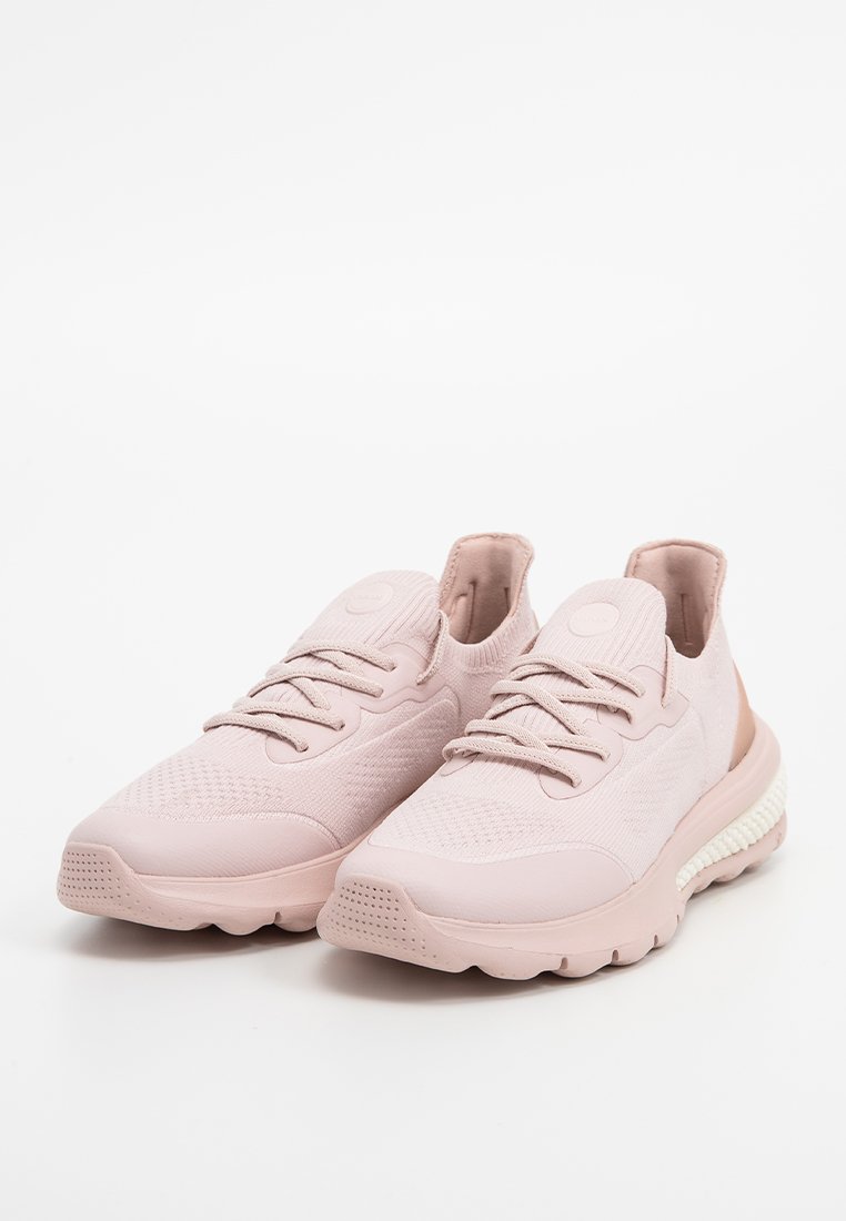 Scarpe da ginnastica rosa chiaro con tomaia in tessuto a maglia, punta rotonda, chiusura con lacci, suola testurizzata e un dettaglio contrastante della soletta bianca.