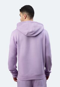 Felpa lavanda con finitura testurizzata, tasca a canguro e cappuccio con cordino, dotata di polsini e orlo a coste. Vista posteriore.