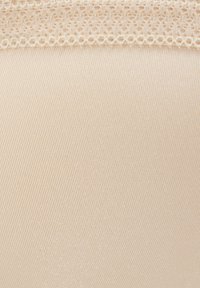 Tessuto nudo senza cuciture con una texture morbida e liscia. Presenta un bordo in pizzo decorativo nella parte superiore, che offre un leggero contrasto rispetto al tessuto.