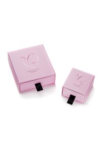 Dva ružové kartónové boxy, jeden väčší a jeden menší, s logom motýľa a čiernou ťahacou klapkou na otváranie. Hladký, matný povrch.