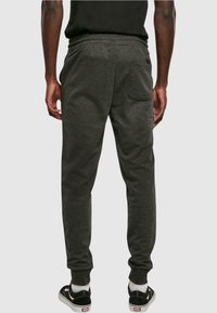 Grijze katoenen joggingsbroeken met een relaxte pasvorm, elastische tailleband, geknoopte enkels en een achterzak. Draag ze met zwarte sneakers en witte sokken.