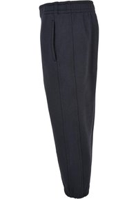 Melnas tapered jogger bikses, izgatavotas no mīksta, teksturēta auduma, ar elastīgu jostasvietu un sānu kabatām praktiskumam.