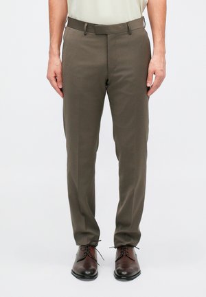 Dark olive green dress pants with a smooth texture, tapered fit, and a belt. Worn with brown leather shoes.