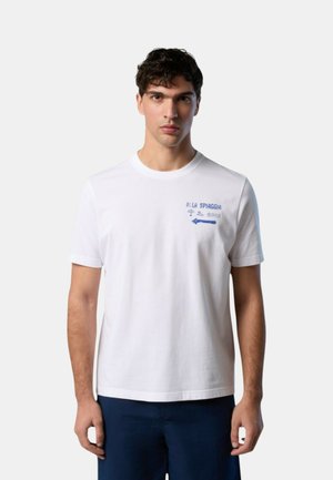 T-shirt bianca in cotone con colletto girocollo e maniche corte. Presenta una grafica blu con testo e icone nell'area del petto sinistro.