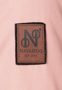 Brown leather patch with embossed text "NAVAHOO EST 2014" on a pink fabric background, bordered by a black felt outline.