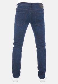 Pantalones de mezclilla azul oscuro con un ajuste slim, que cuentan con bolsillos traseros y una etiqueta de cuero en la cintura. Textura suave, diseño sencillo.