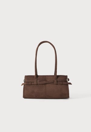 Braune Wildleder-Handtasche mit zwei stabilen Griffen, rechteckiger Form und dekorativem Riemen-Detail an der Vorderseite.