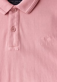 Růžová pánská polo košile se dvěma knoflíky, texturovaná tkanina a diskrétní vyšitý logo palmy a písmen na hrudi.