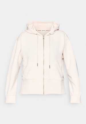 Sudadera con cremallera de color rosa claro con una textura ribeteada sutil, cordones ajustables y bolsillos laterales. Tejido suave, corte relajado y diseño con capucha.