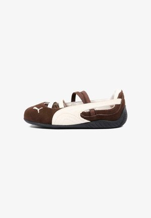 Scarpa piatta Puma marrone e beige con due sottili cinturini sulla parte superiore e una suola nera testurizzata.