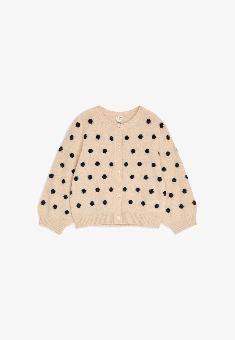 Cardigan beige en tricot avec des pois noirs duveteux, manches longues bouffantes, fermeture par boutons et poignets et ourlet côtelés.