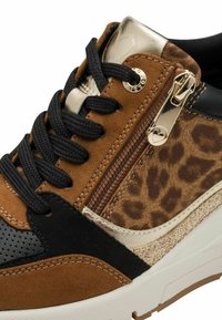 Sneaker marrone e nero con un mix di camoscio e pelle, dettagli dorati e un pannello a stampa leopardata. Include lacci neri e una cerniera laterale.