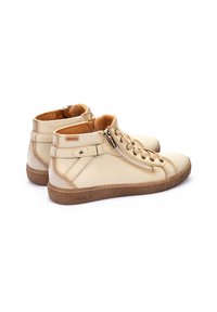 Sneaker alte in pelle beige con finitura texturizzata, dotate di una cerniera laterale, lacci e suola in gomma marrone. All'interno presenta una morbida fodera color nocciola.