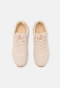 Lys rosa sneakers med perforert design, rund tå og flate snørebånd. Myk innvendig fôr og gummisåle med teksturert grep.