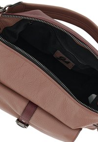 Borsa in pelle con un esterno in mauve testurizzato e fodera in tessuto scuro. Presenta una chiusura con cerniera, una tasca interna e un accento in fettuccia bordeaux.
