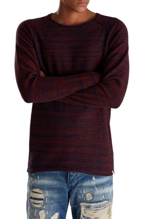 Maroon ja tummansininen raidallinen pitkähihaine paita, jossa on pyöreä kaula-aukko ja raglan-hihat, yhdistettyinä kuluneisiin sinisiin farkkuihin. Teksturoitu kangas.
