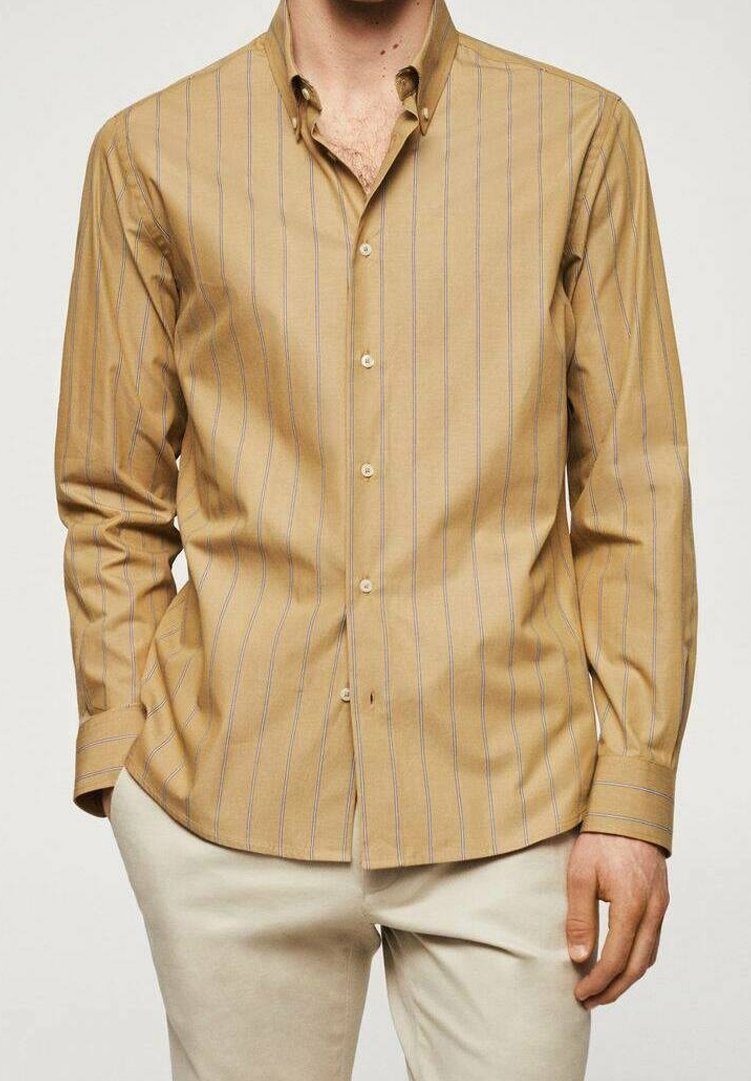 Camicia a maniche lunghe color tan con strisce verticali blu, colletto a punta e bottoni frontali. Realizzata in tessuto liscio con una vestibilità aderente.