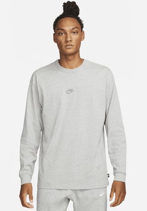 Langärmliges graues Sweatshirt aus weichem Stoff, mit einem kleinen, gestickten Nike-Logo auf der Brust und gerippten Bündchen.