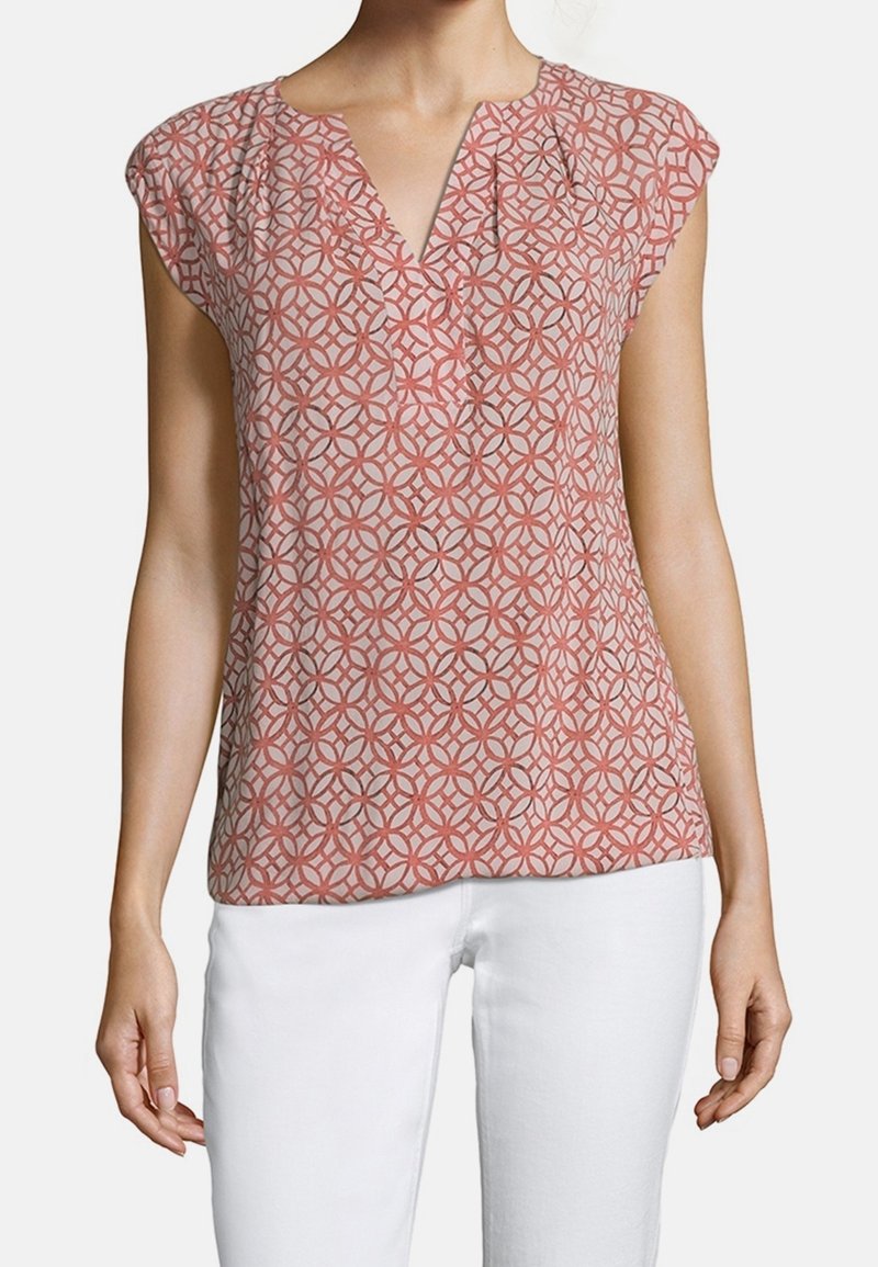 Blusa a manica corta in corallo con un motivo geometrico, presenta un collo a V, dettagli arricciati e un tessuto morbido e leggero.