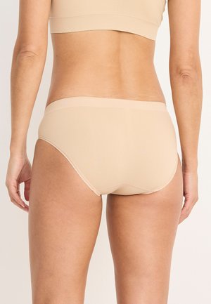 Beige naadloze ondergoed met een lage taille, een gladde textuur en minimale details. Beschikt over een zachte elastische tailleband.
